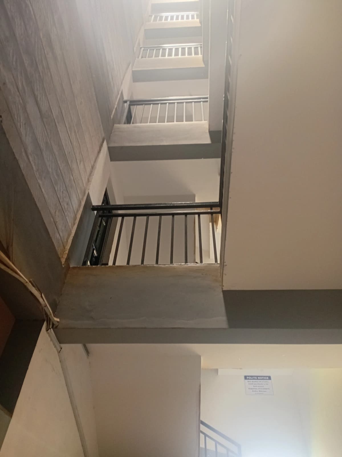 Multi-story stairwell with metal railings, minimal finishes