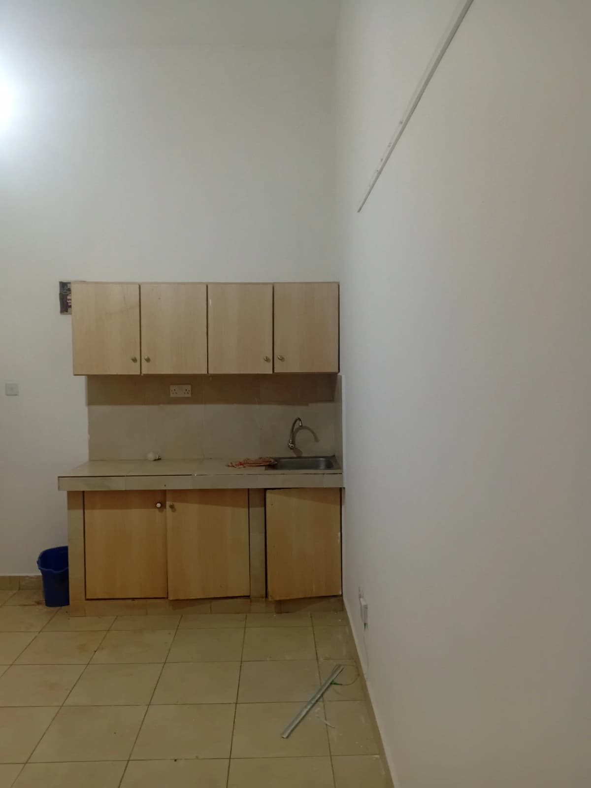 Compact kitchen with wooden cabinetry and basic sink setup