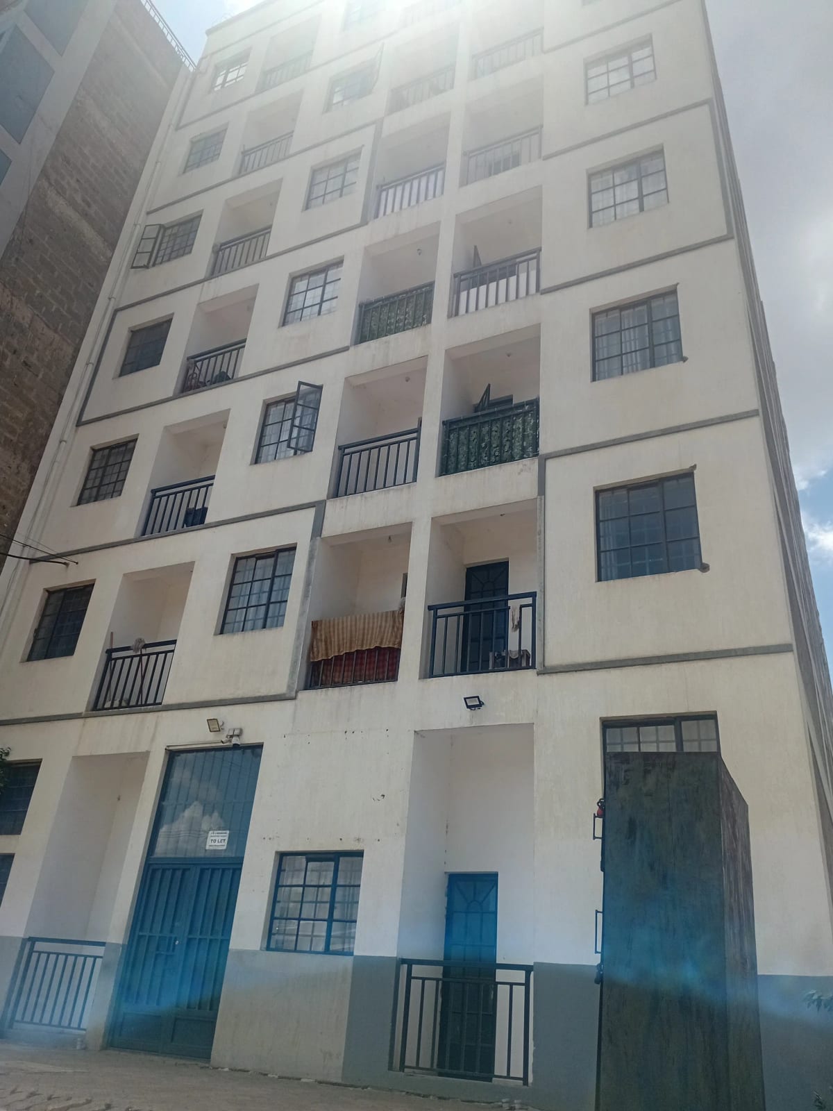 Multi-story residential building facade with balconies and blue accents