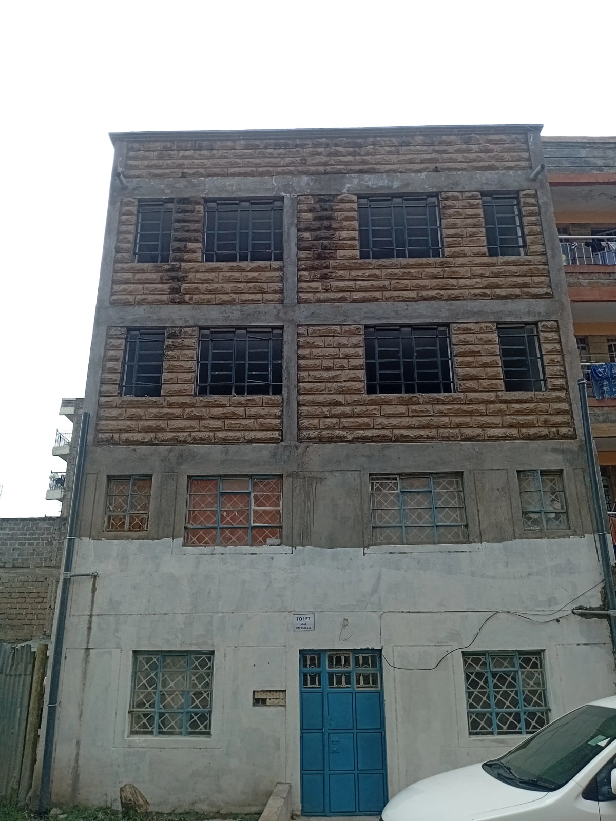 Multi-story residential building facade with blue entrance door