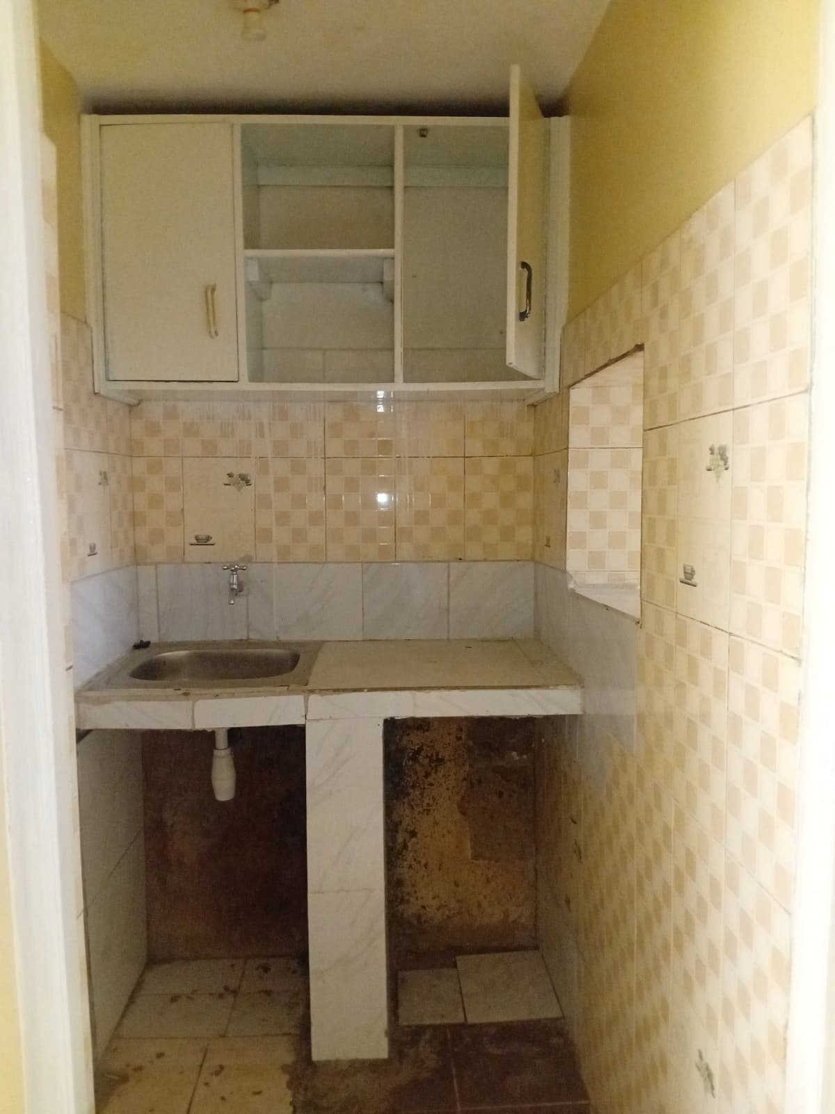 Compact kitchen with single sink and overhead storage cabinets