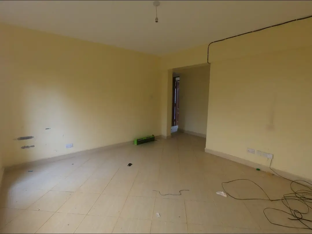 Empty living room with yellow walls and bare flooring