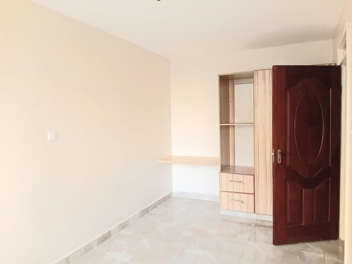 Unfurnished bedroom with built-in wardrobe and wooden door