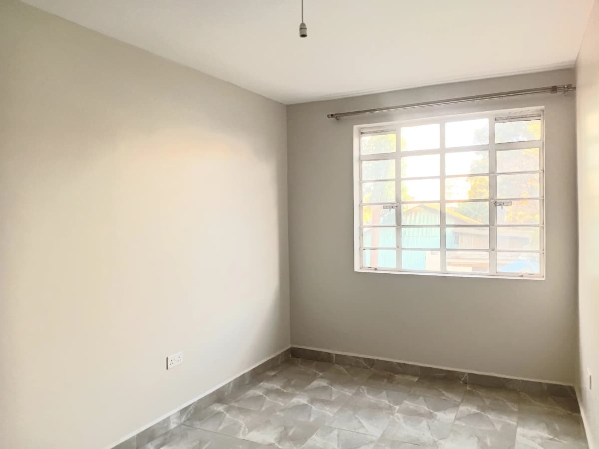 Bright bedroom with large window and neutral finishes