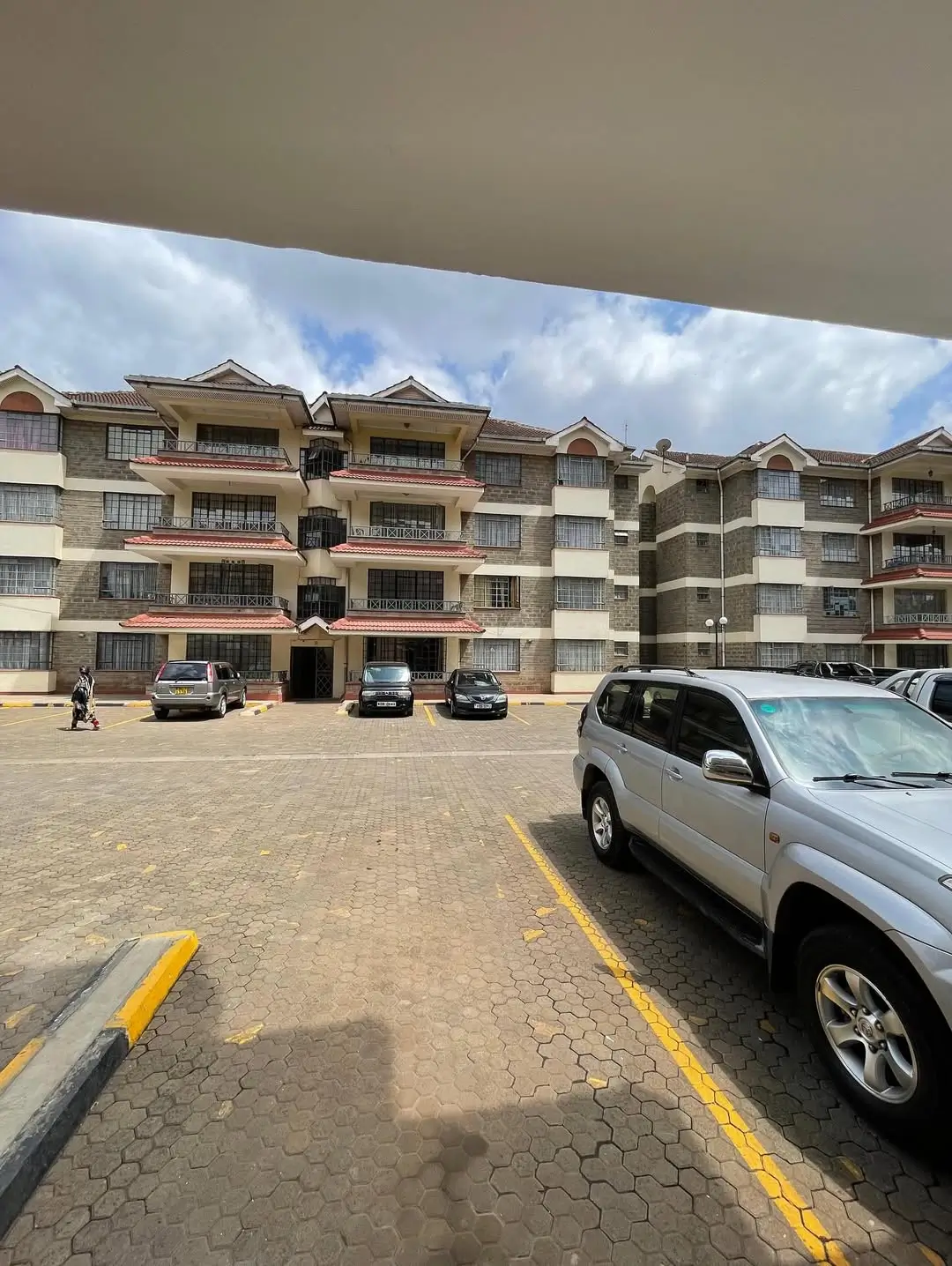 Apartment complex parking lot with marked spaces and vehicles