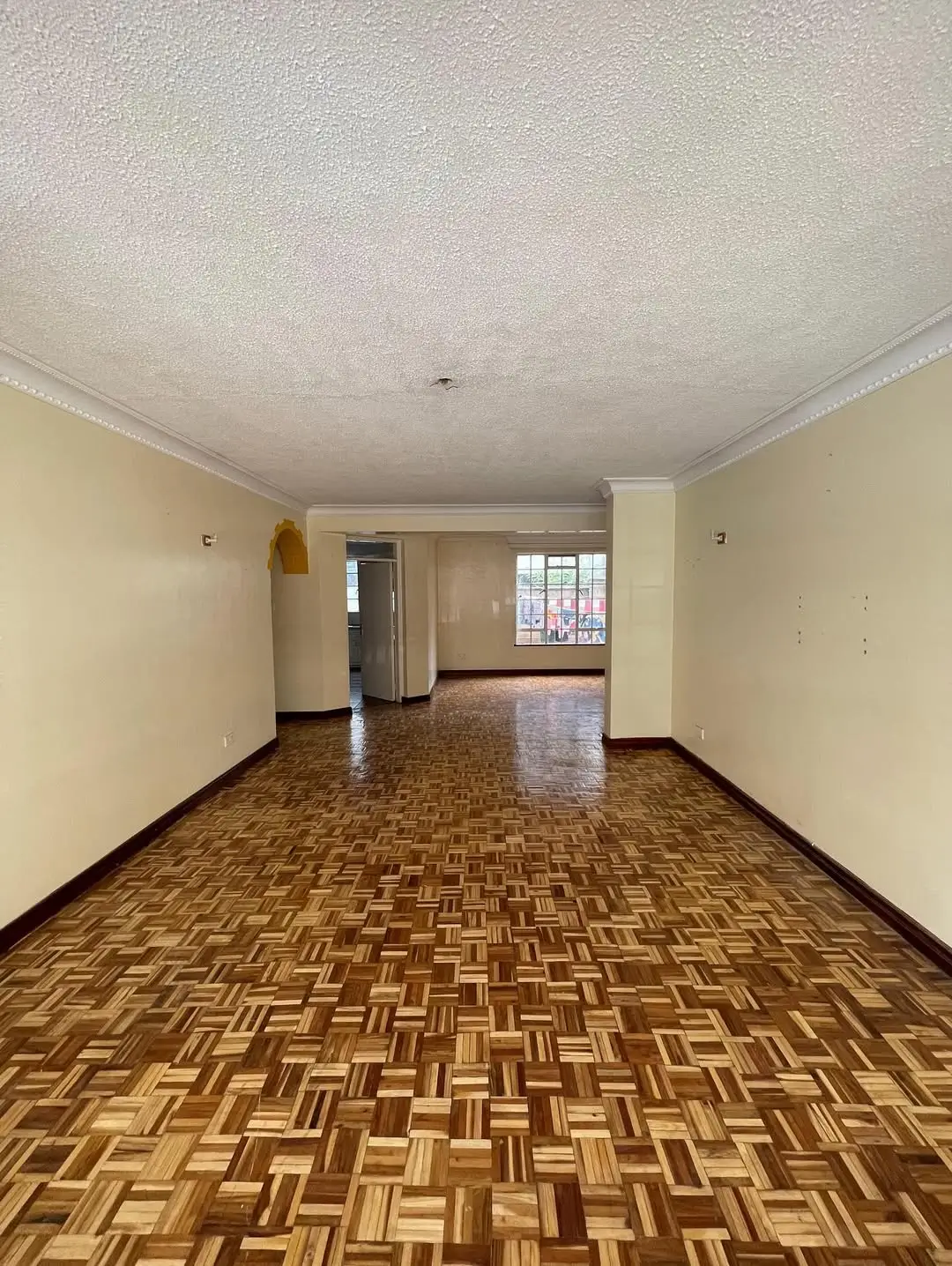 Spacious living room with parquet flooring and natural light