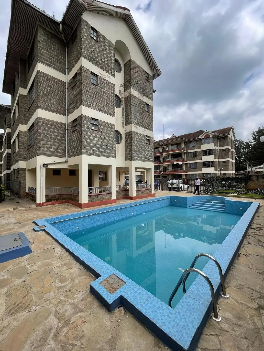 Residential swimming pool with blue tiles and metal ladder