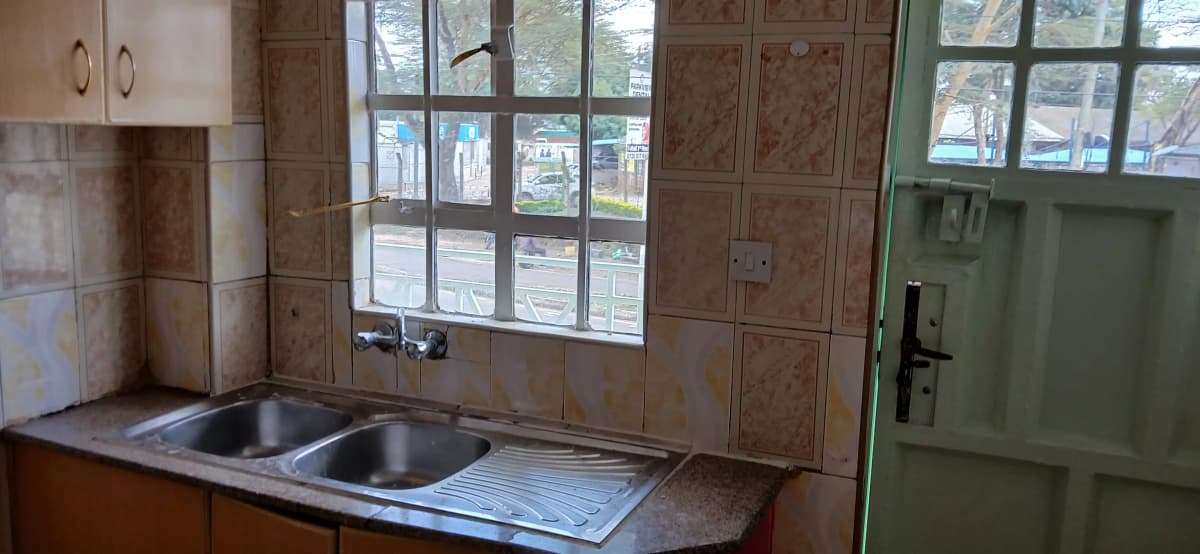 Kitchen with double sink and wooden cabinetry, large windows