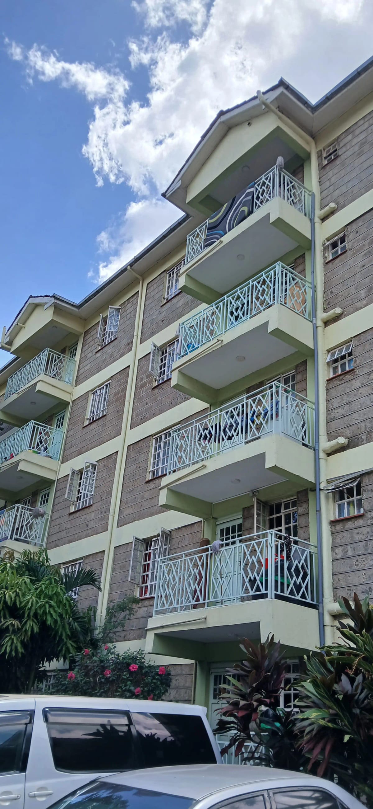 Multi-story residential building facade with balconies and greenery