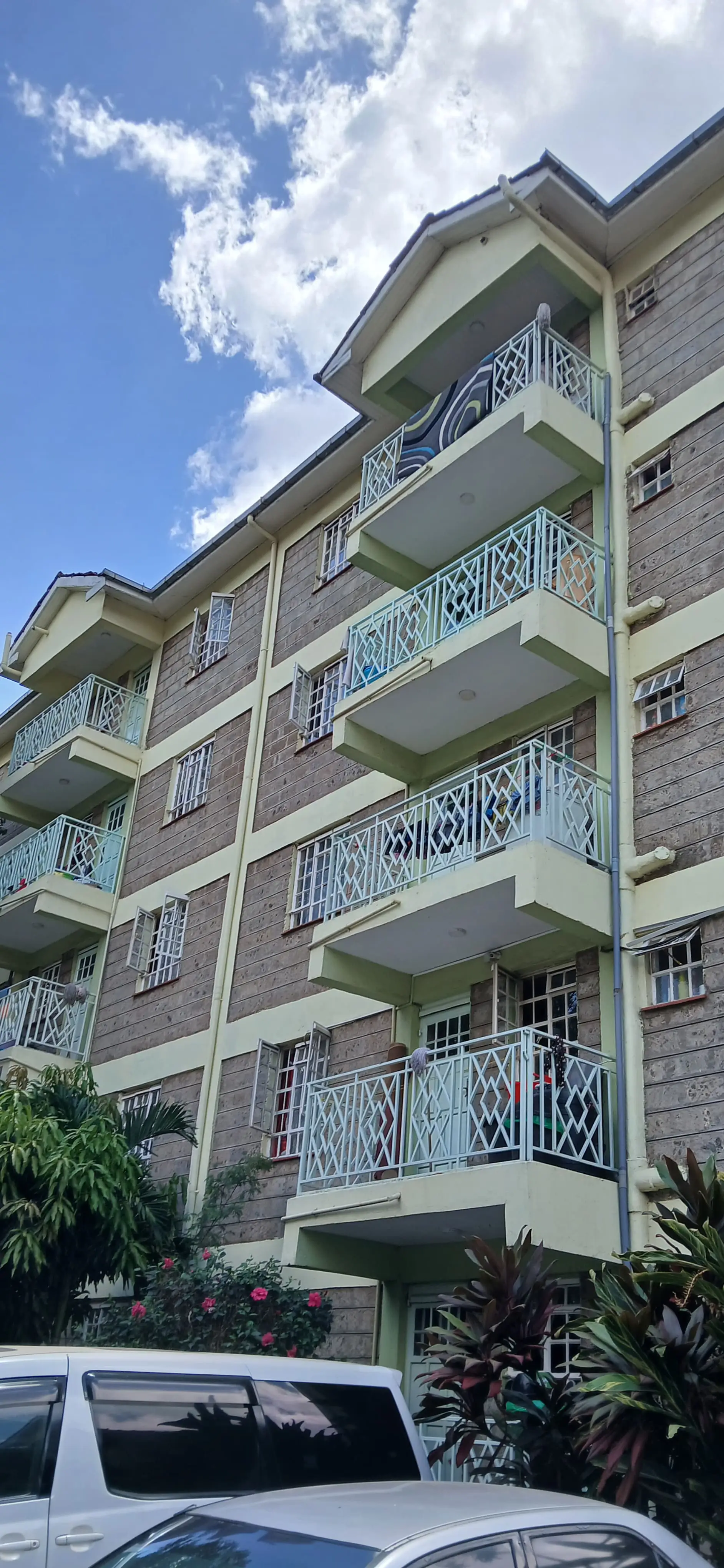 Multi-story residential building facade with balconies and greenery