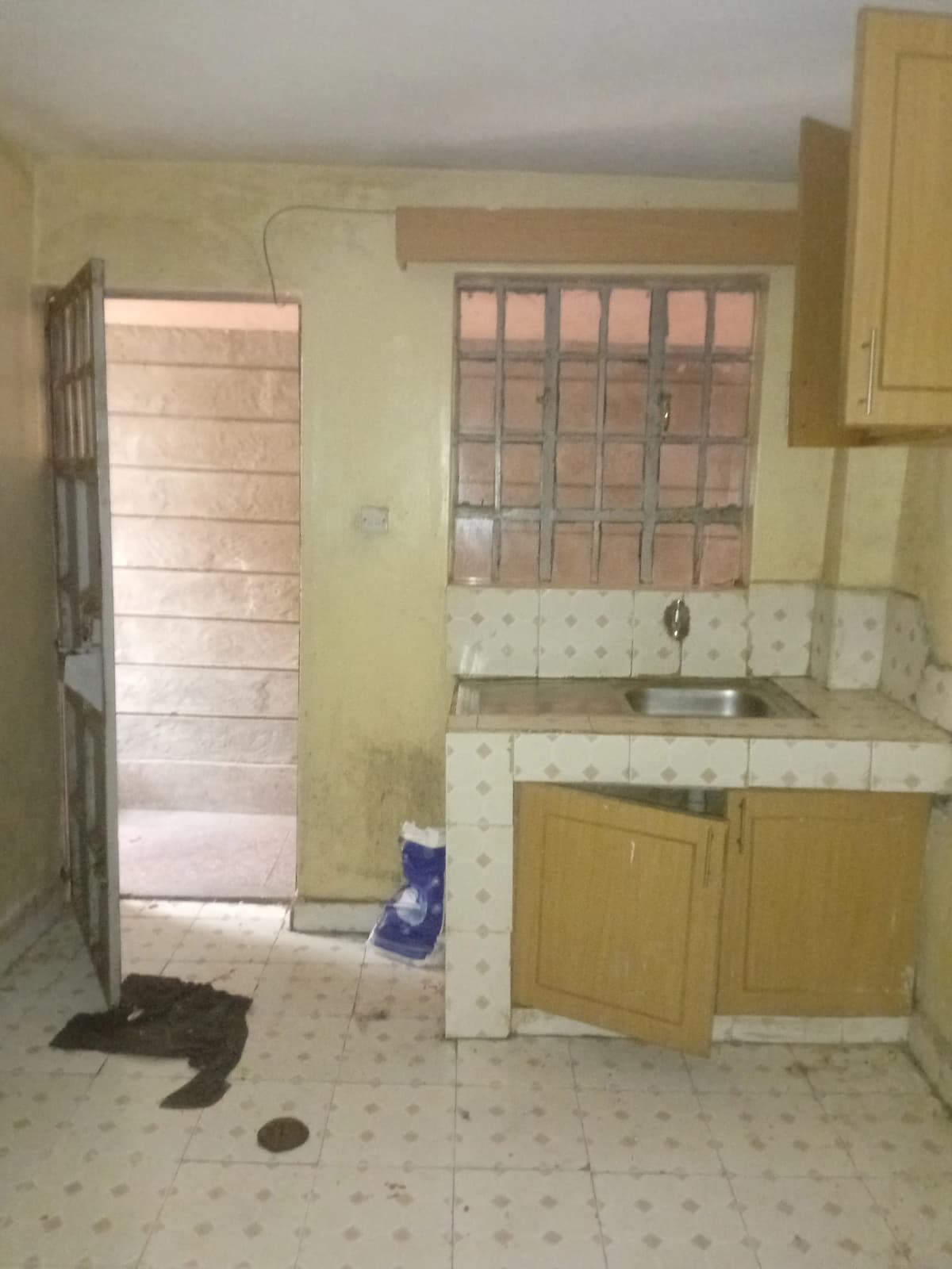 Compact kitchen with yellow cabinets and tiled countertop