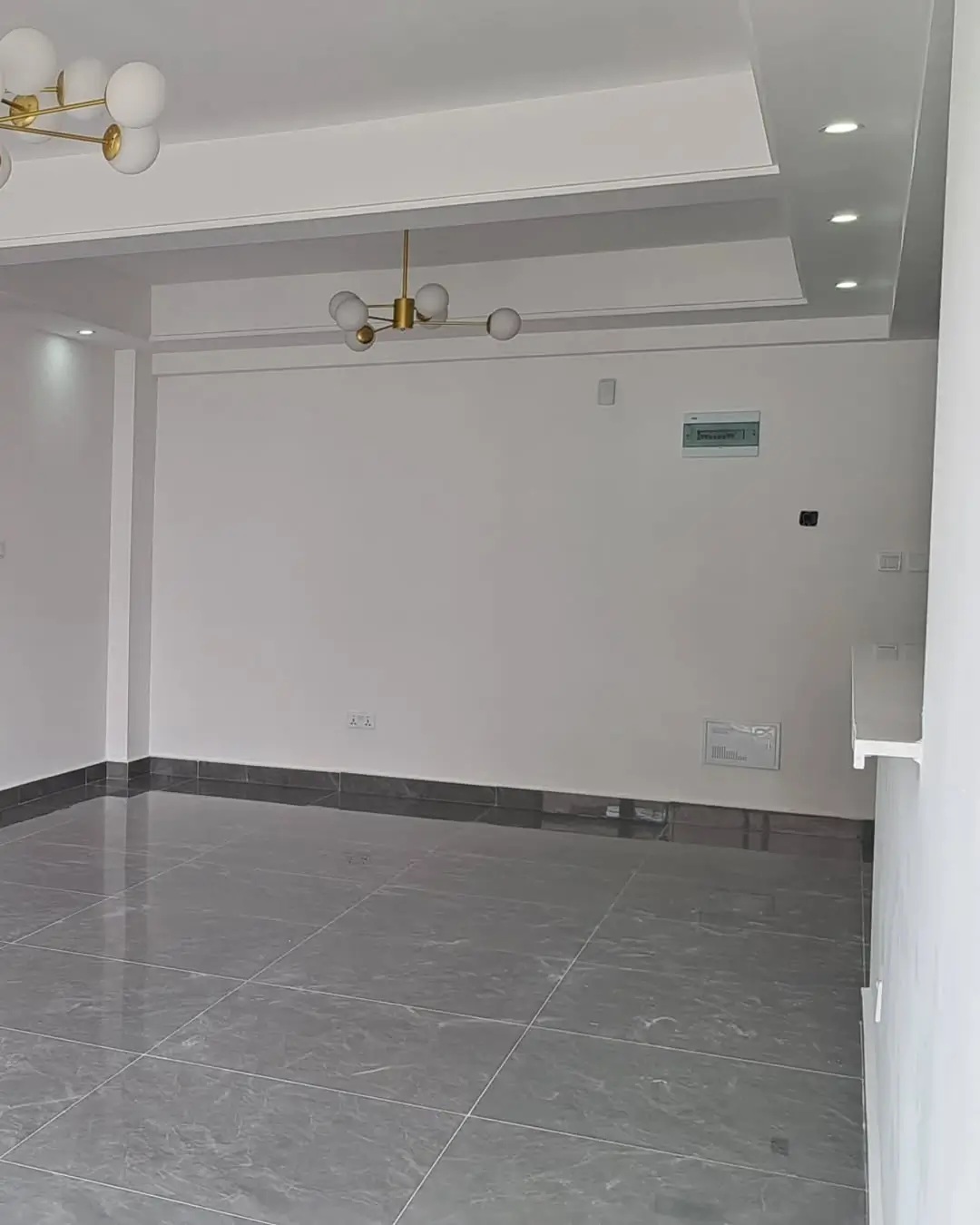 Minimalist living space with dark marble flooring and recessed lighting