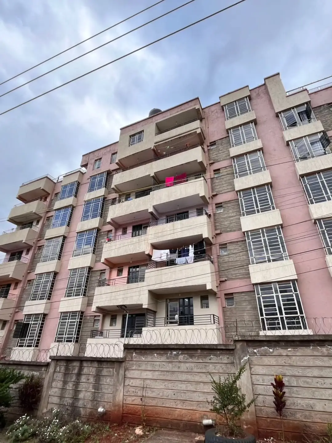 Multi-story residential apartment building with pink facade