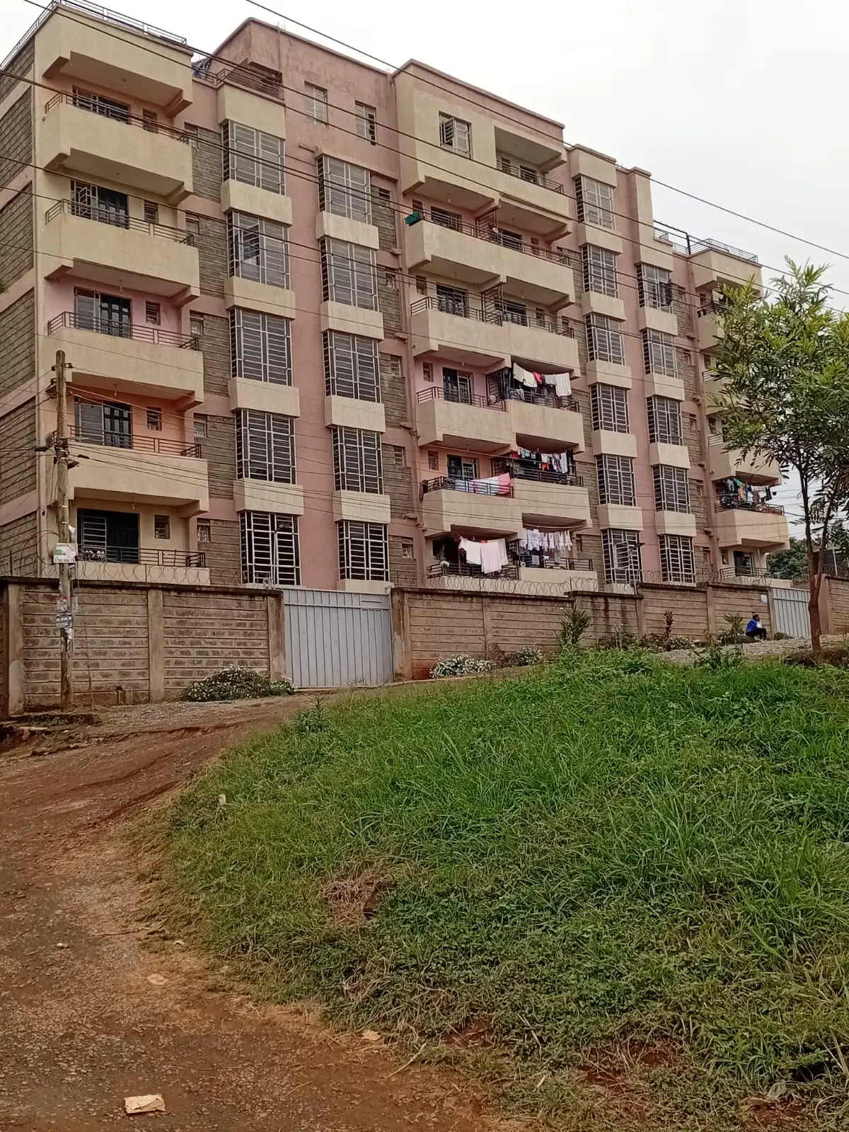 Multi-story residential apartment building with green lawn frontage