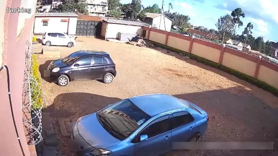 Compound parking area with multiple vehicles and red boundary wall