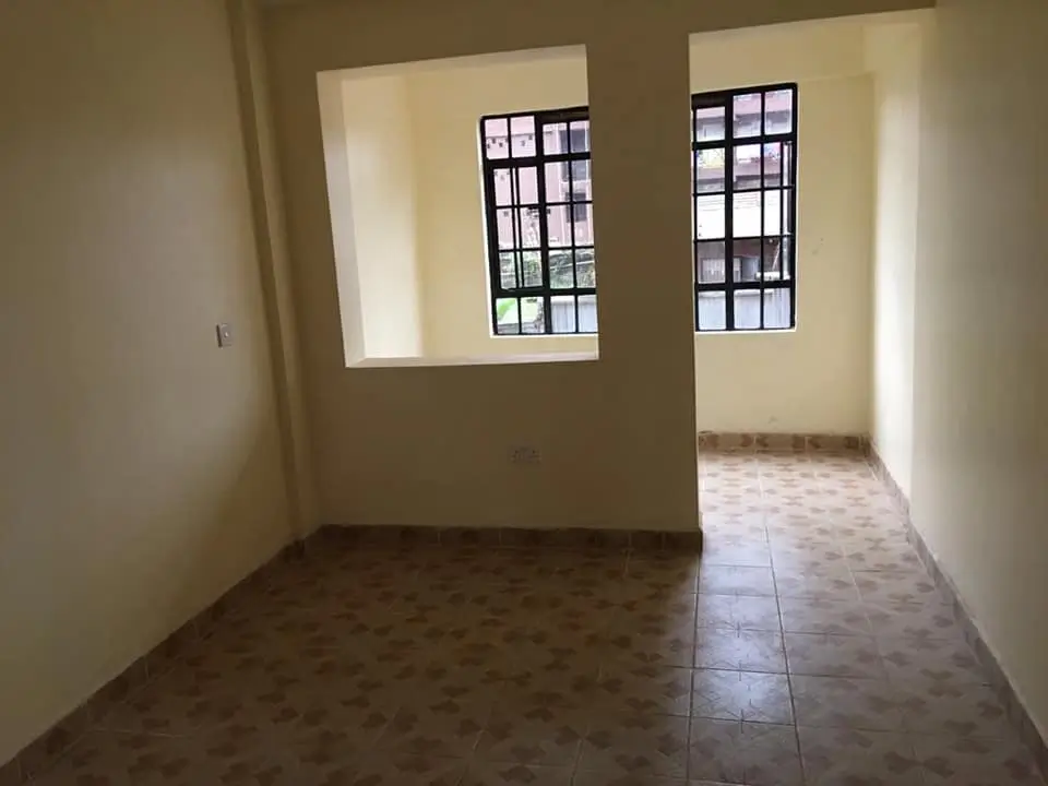 Bright open-plan living space with large windows and tile flooring
