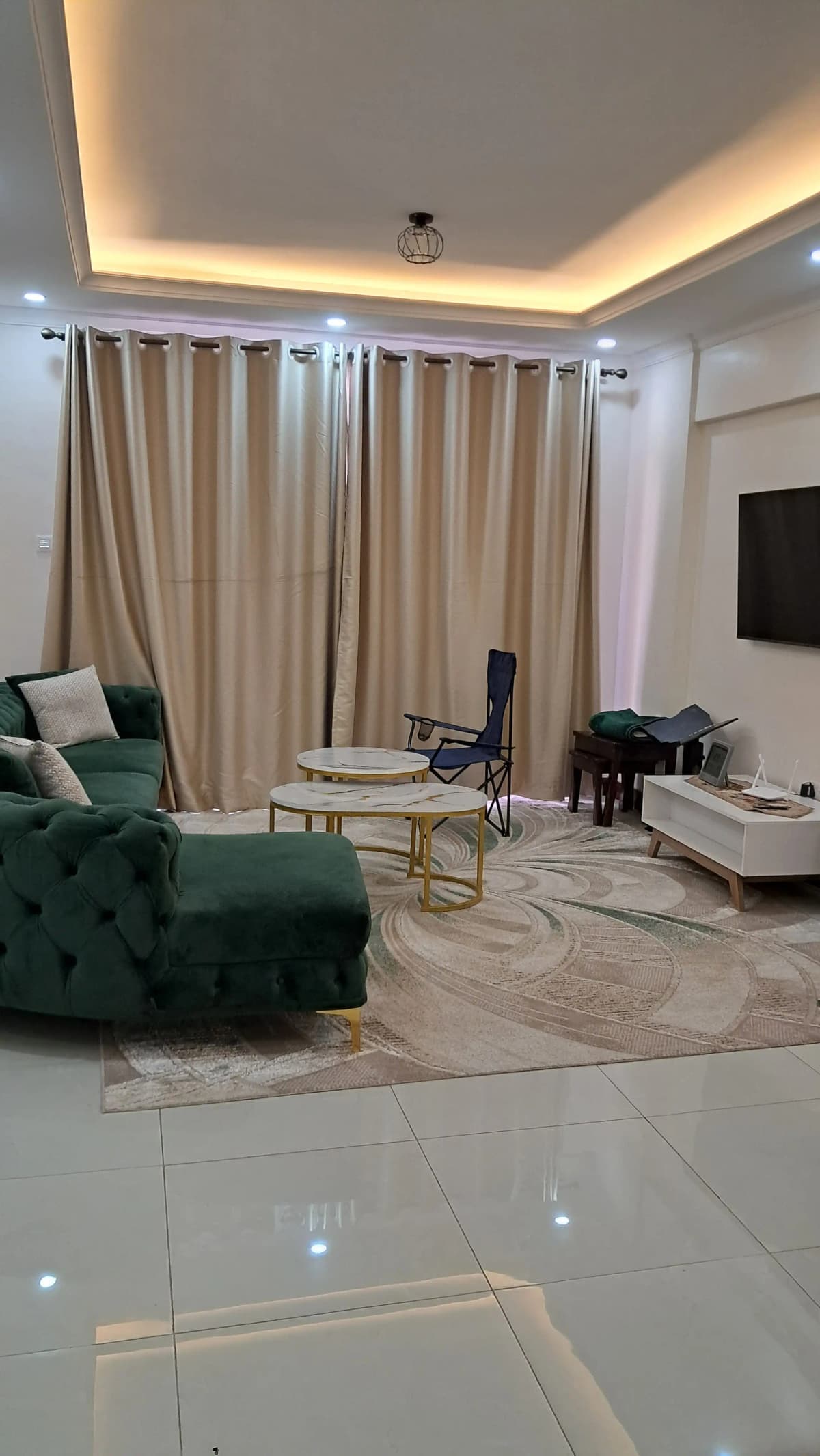 Modern living room with green velvet sofa and ambient ceiling lighting