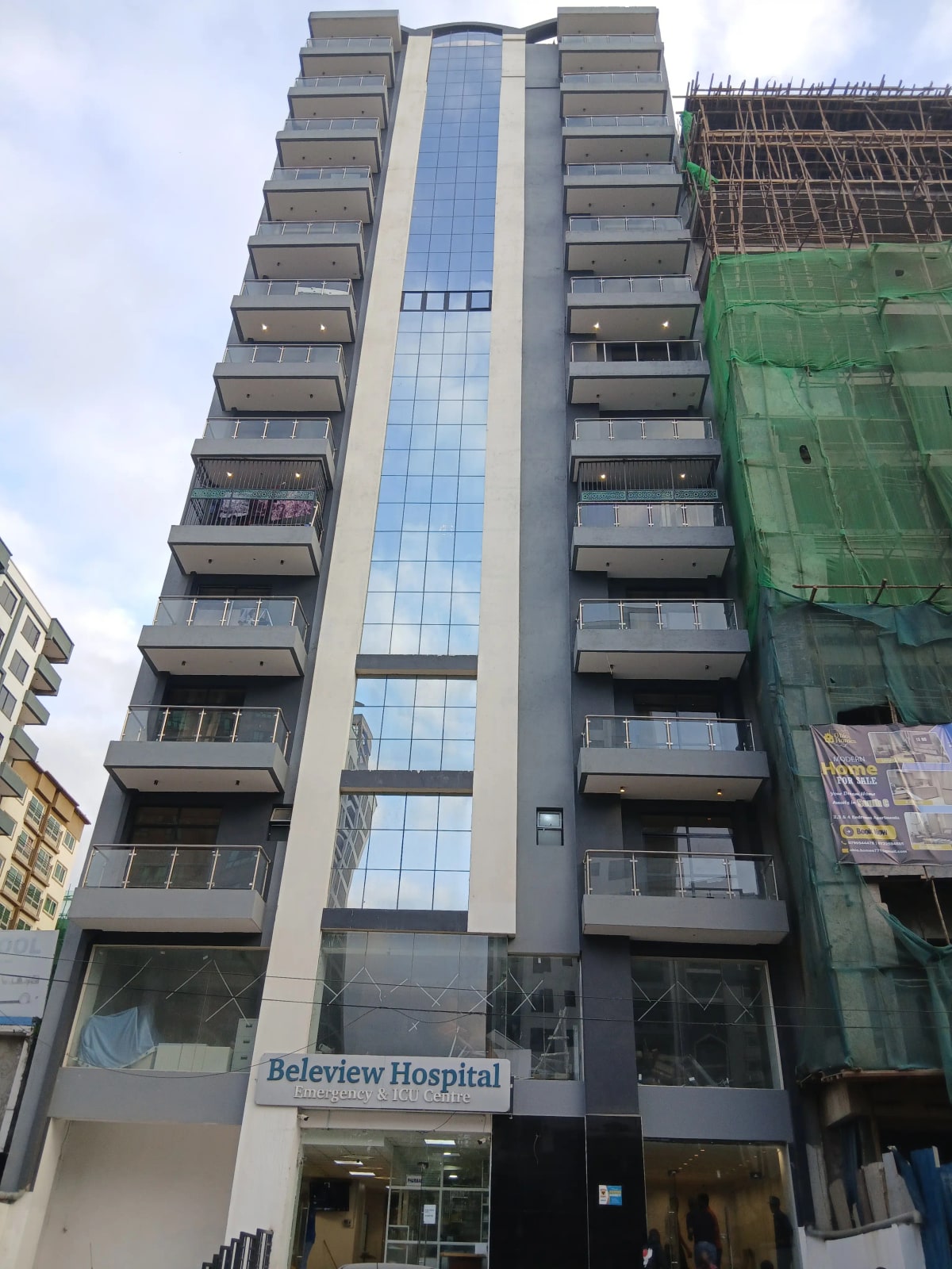 Modern multi-story residential building with glass facade and balconies