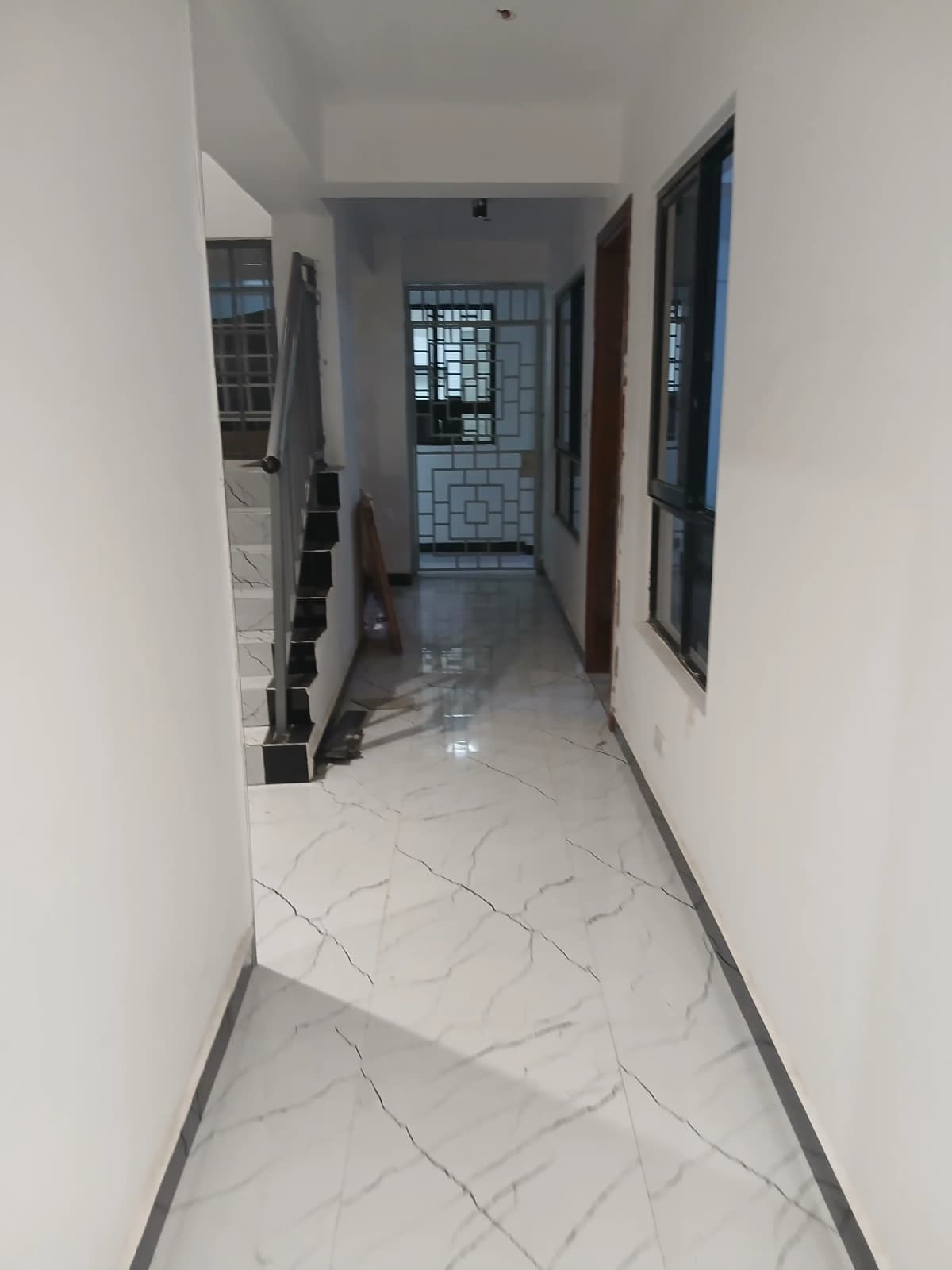 Bright corridor with marble flooring and multiple doorways