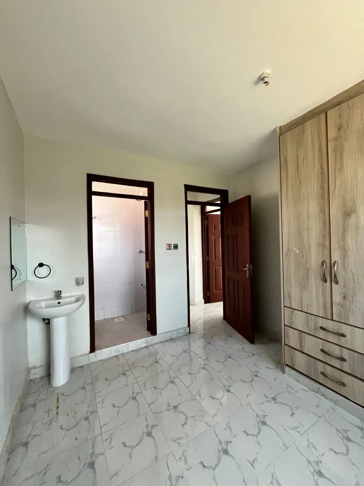 Spacious bedroom with ensuite bathroom and wooden wardrobe