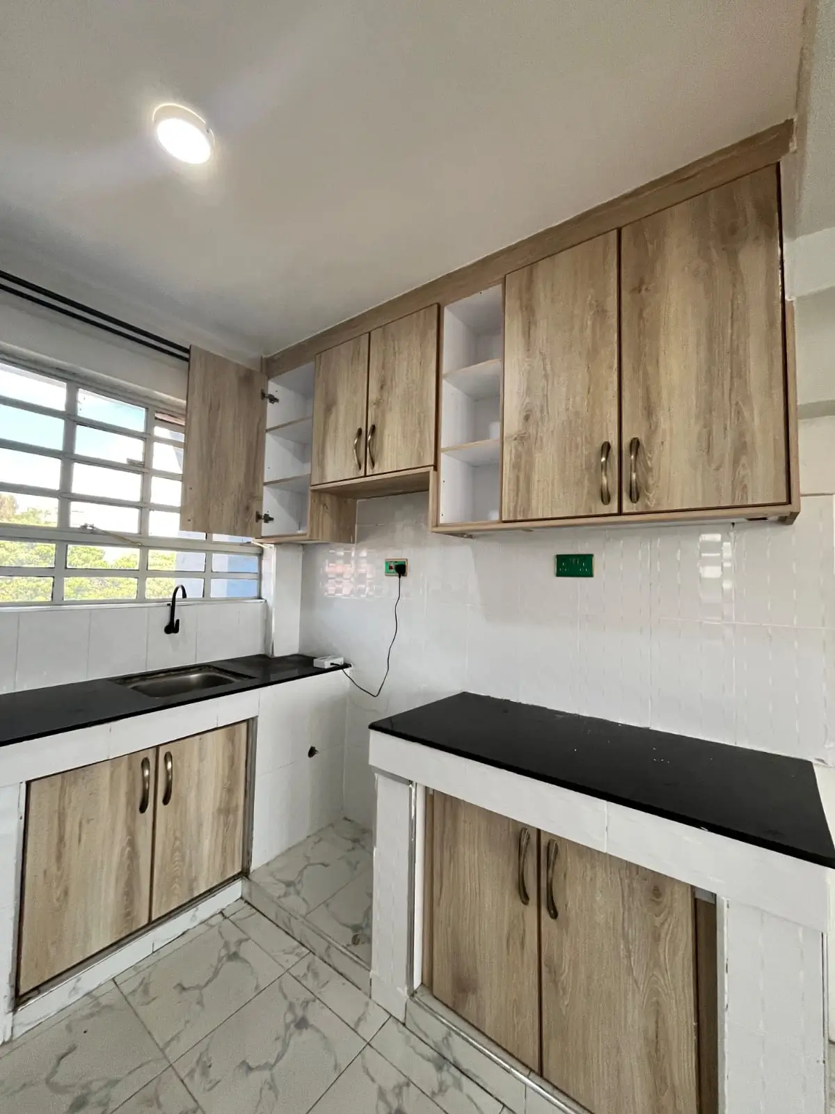 Modern kitchen with wood cabinets and black countertops
