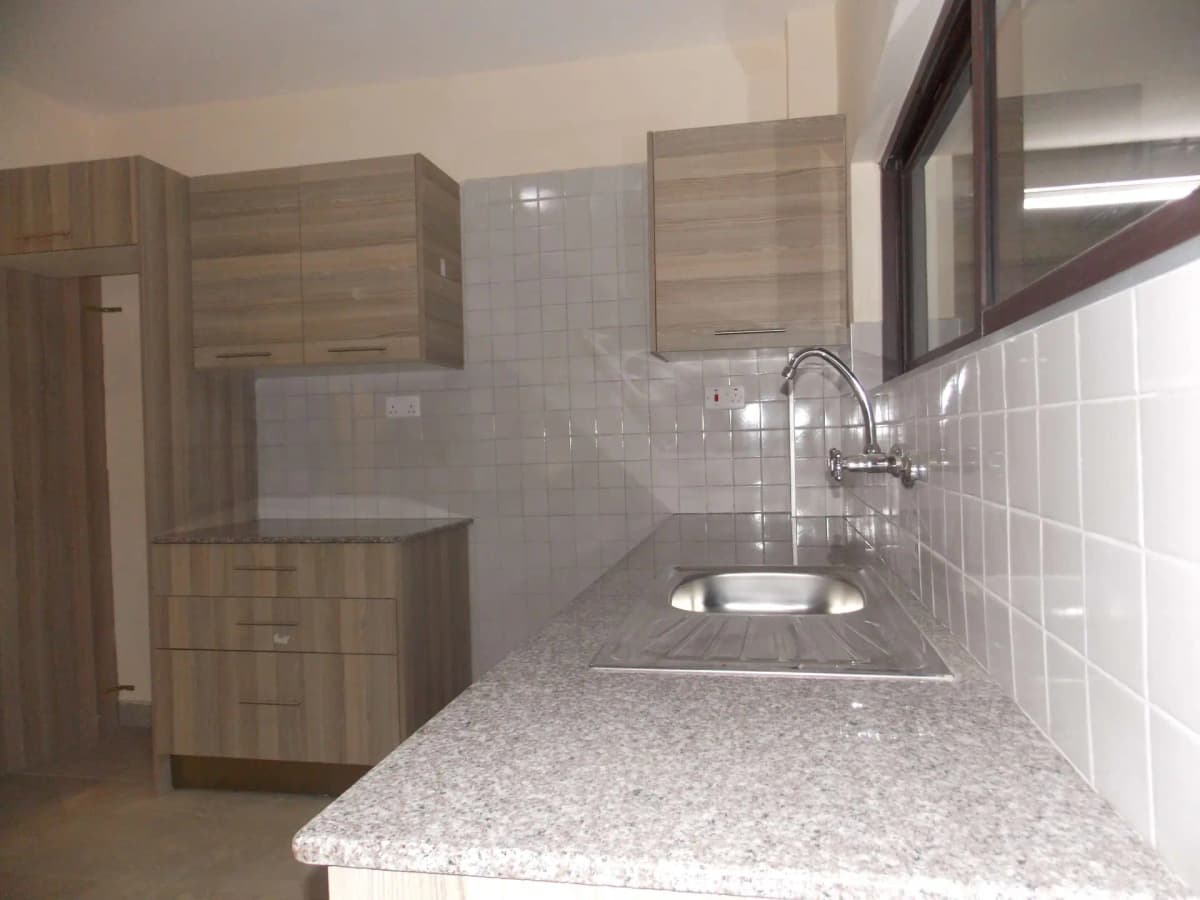 Compact kitchen with granite countertop and white tile backsplash