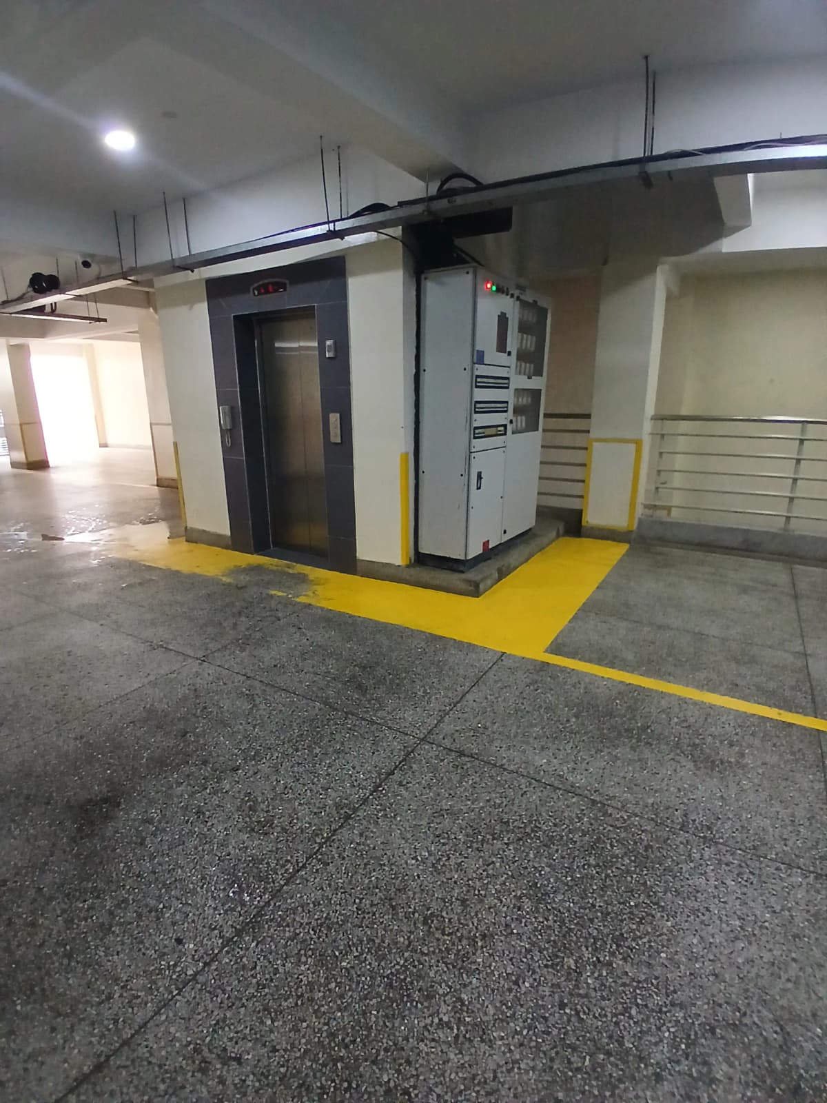 Underground parking garage with elevator access and yellow markings
