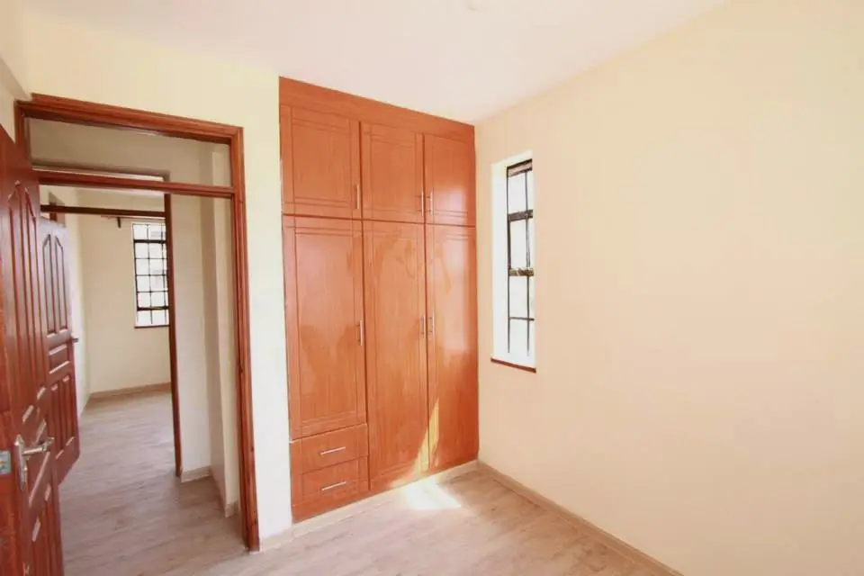 Spacious bedroom with wooden wardrobe and natural light