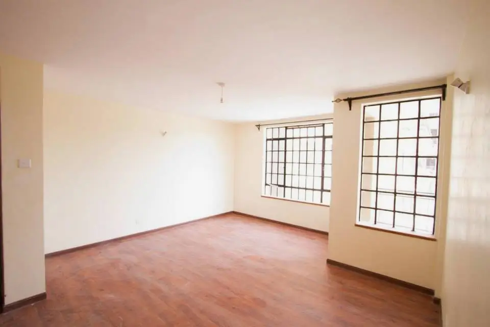 Spacious living room with wooden floors and large windows
