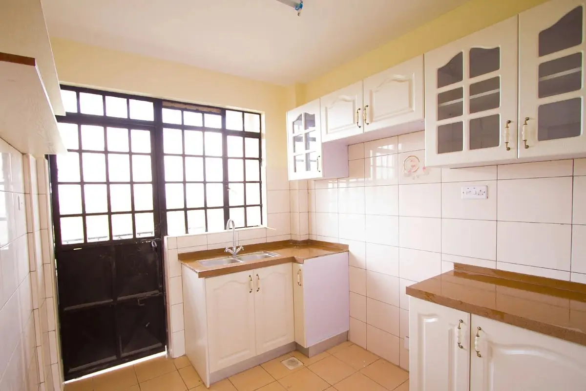 Compact kitchen with white cabinetry and wooden countertops