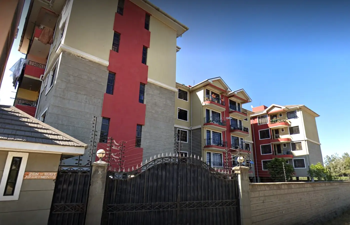 Modern multi-story apartment complex with red and cream facade