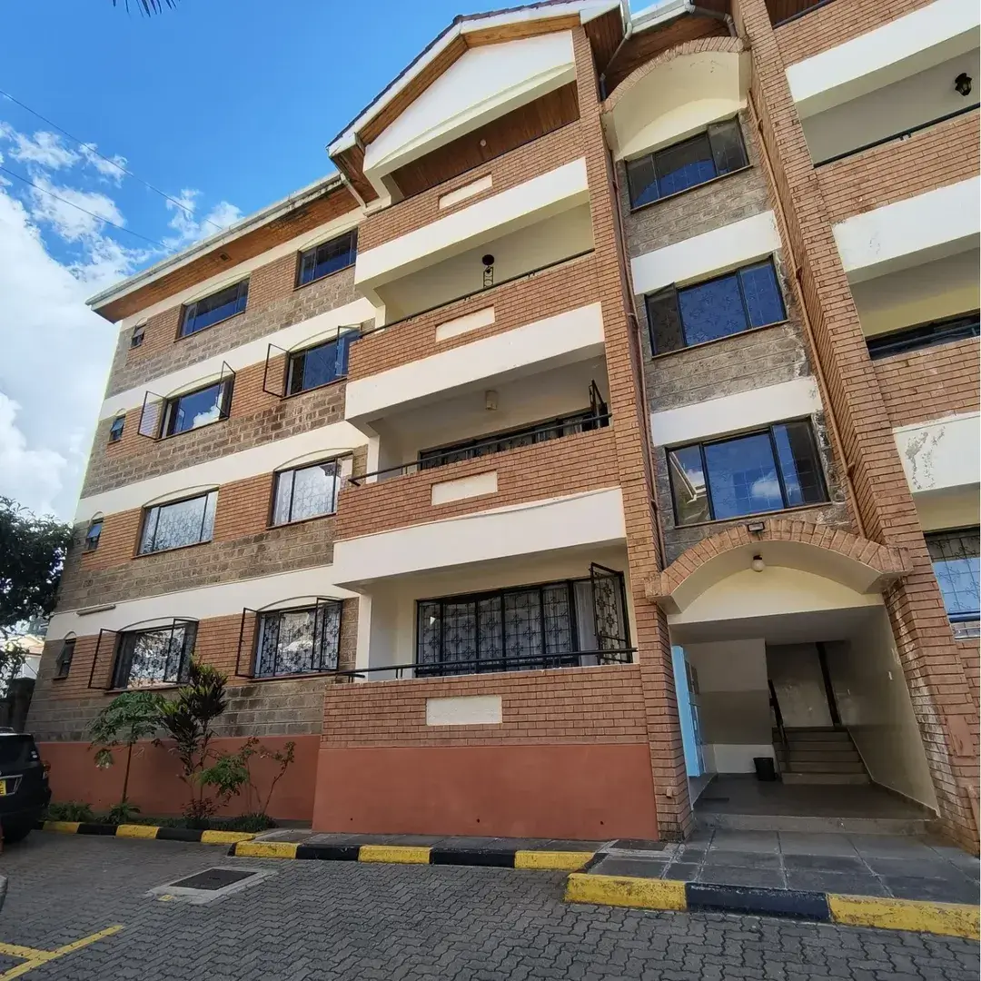 Multi-story brick apartment building with balconies and entrance