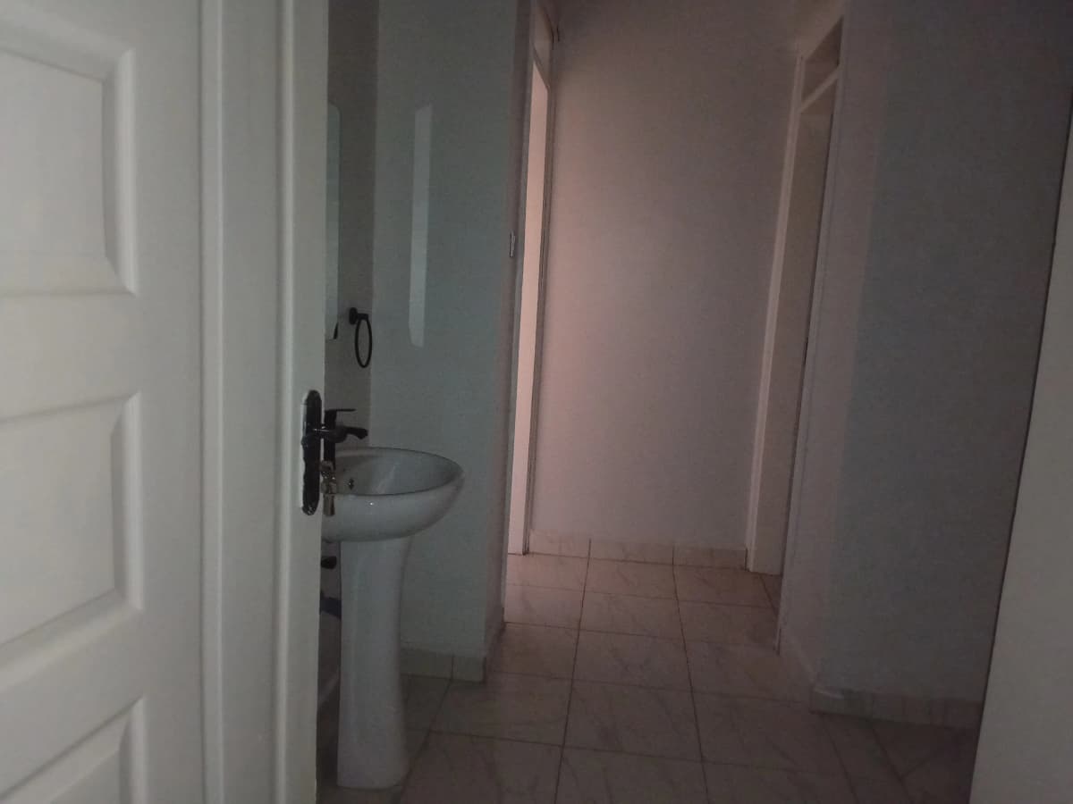 Compact bathroom with pedestal sink and tiled flooring