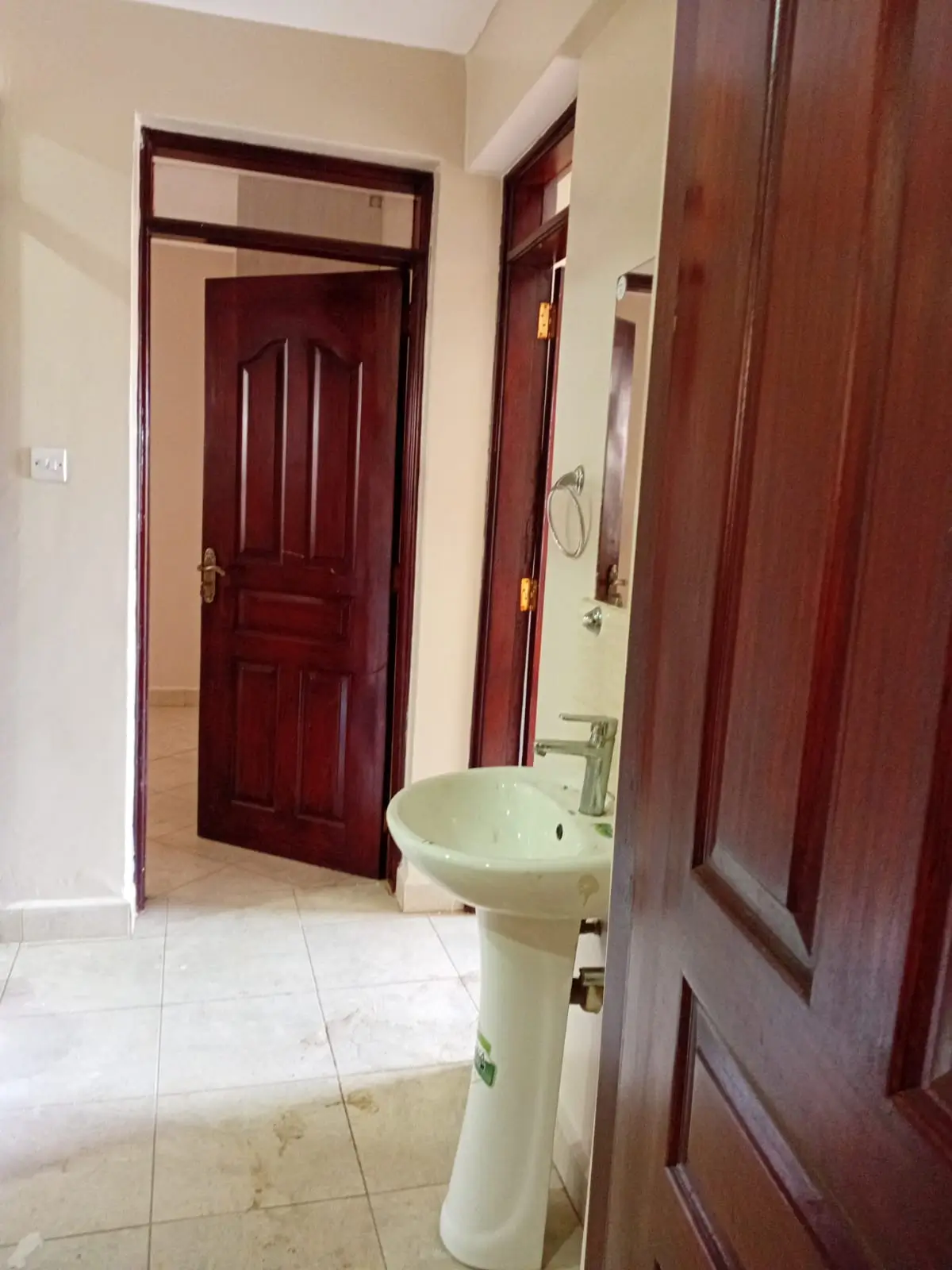Bathroom with pedestal sink and dark wood doors