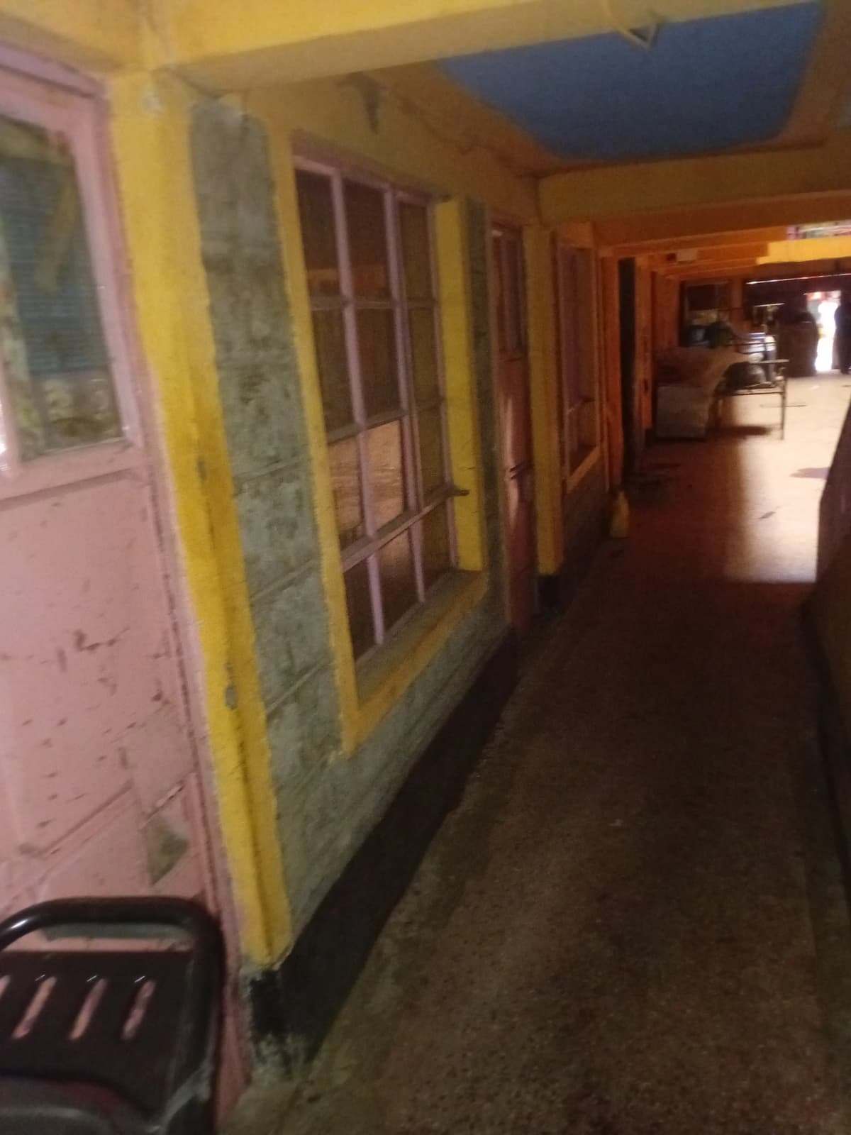 Corridor with yellow trim and numbered doors, under renovation