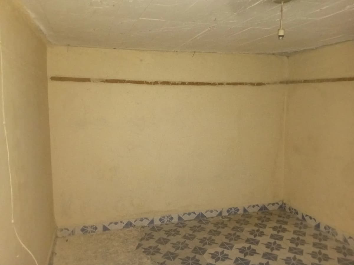 Empty bedroom with bare walls and patterned floor covering