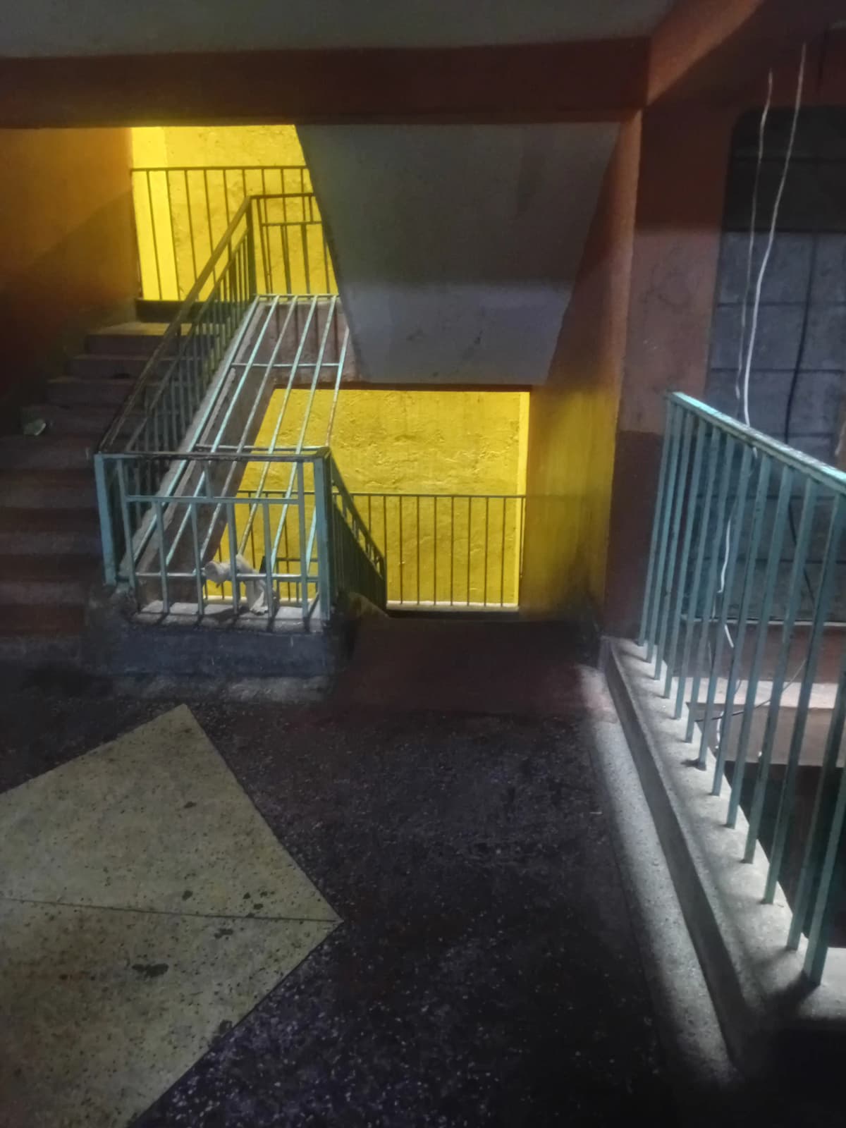 Underground parking area with yellow safety barriers and railings