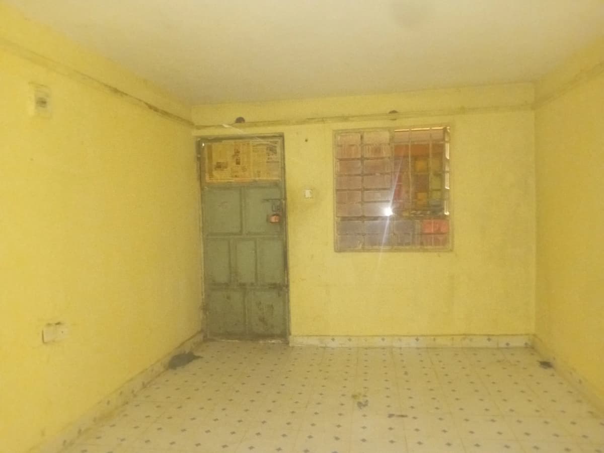 Empty yellow room with minimal fixtures and natural light