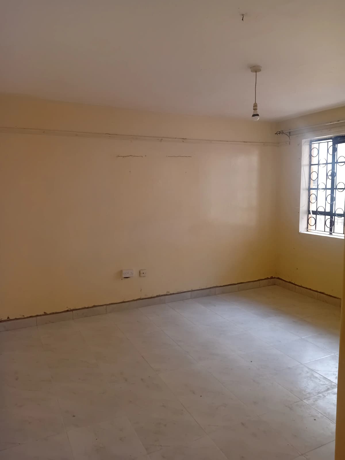 Empty living room with bare walls and concrete floor