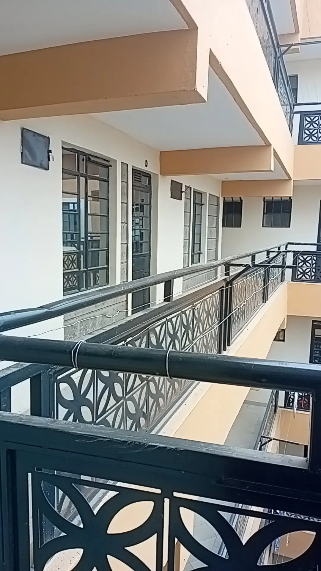 Multi-level building corridor with metal railings and glass doors