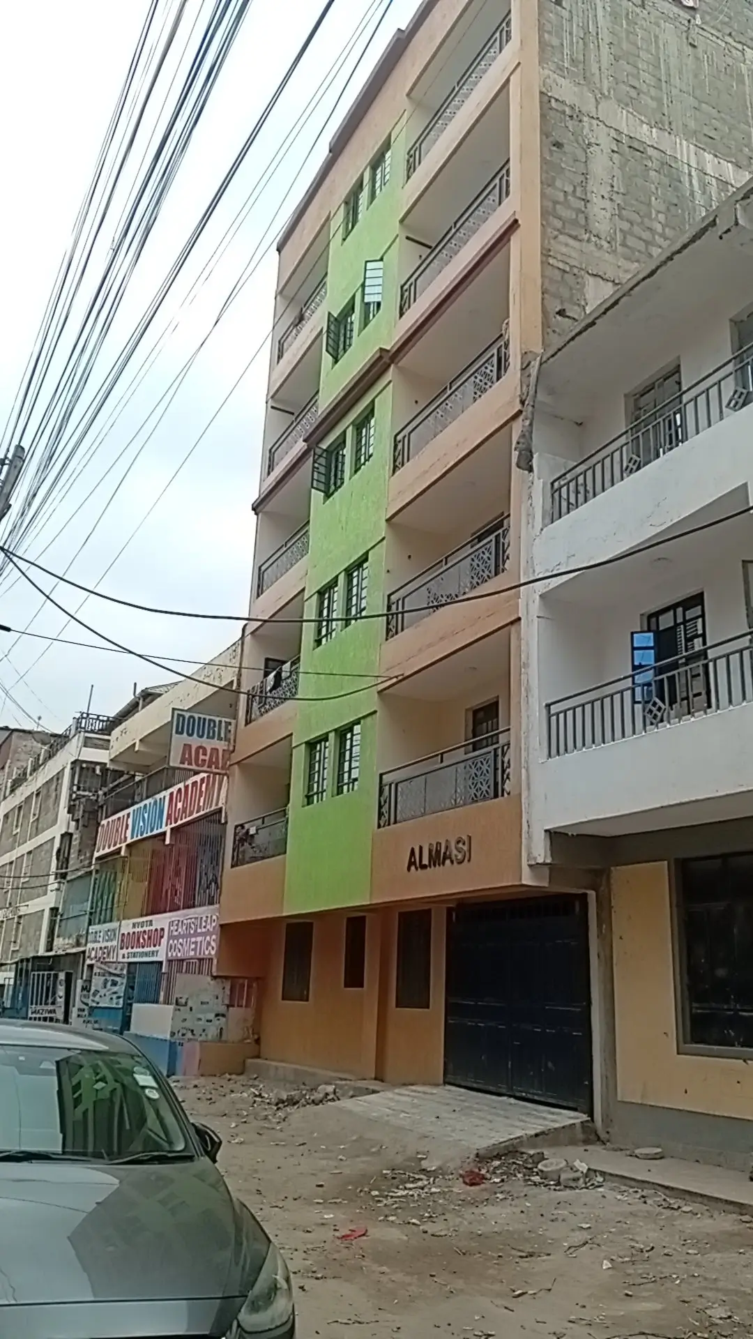 Multi-story residential building facade with balconies and street view