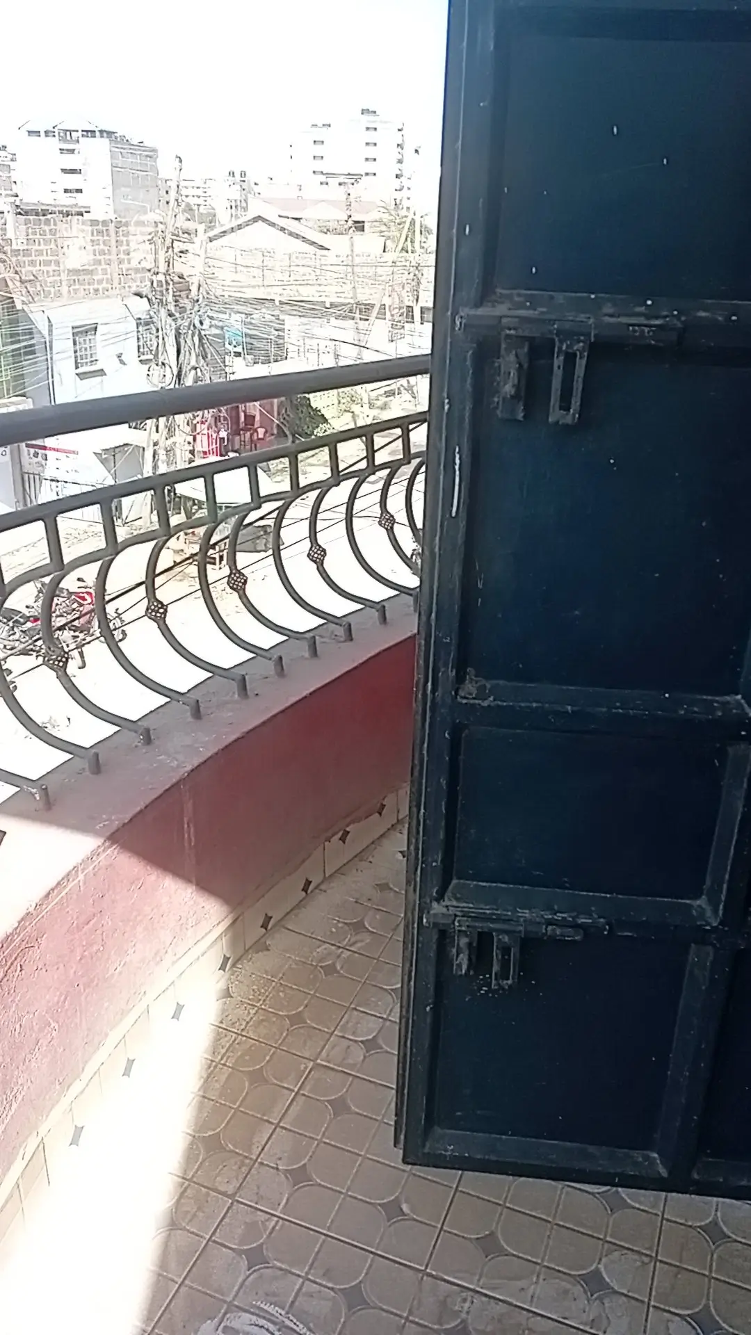 Balcony with metal railing overlooking urban cityscape