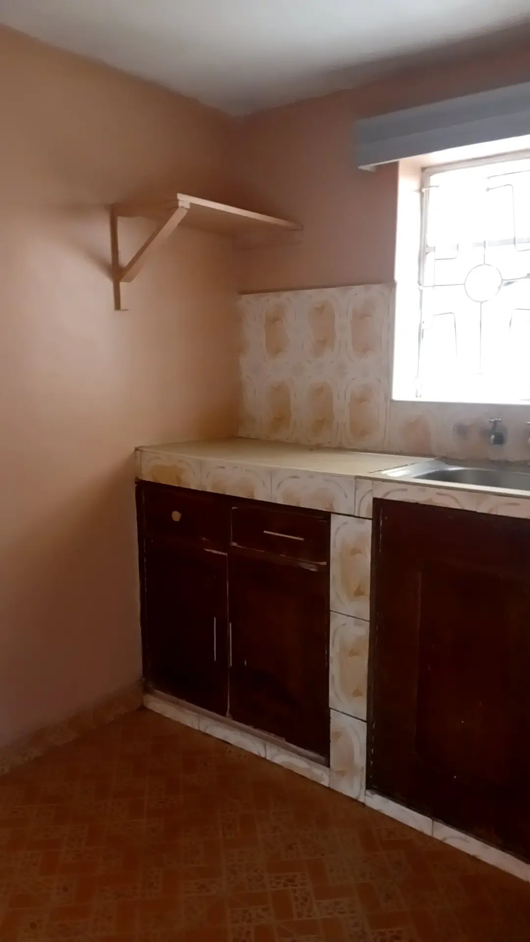 Compact kitchen with dark cabinets and light countertop