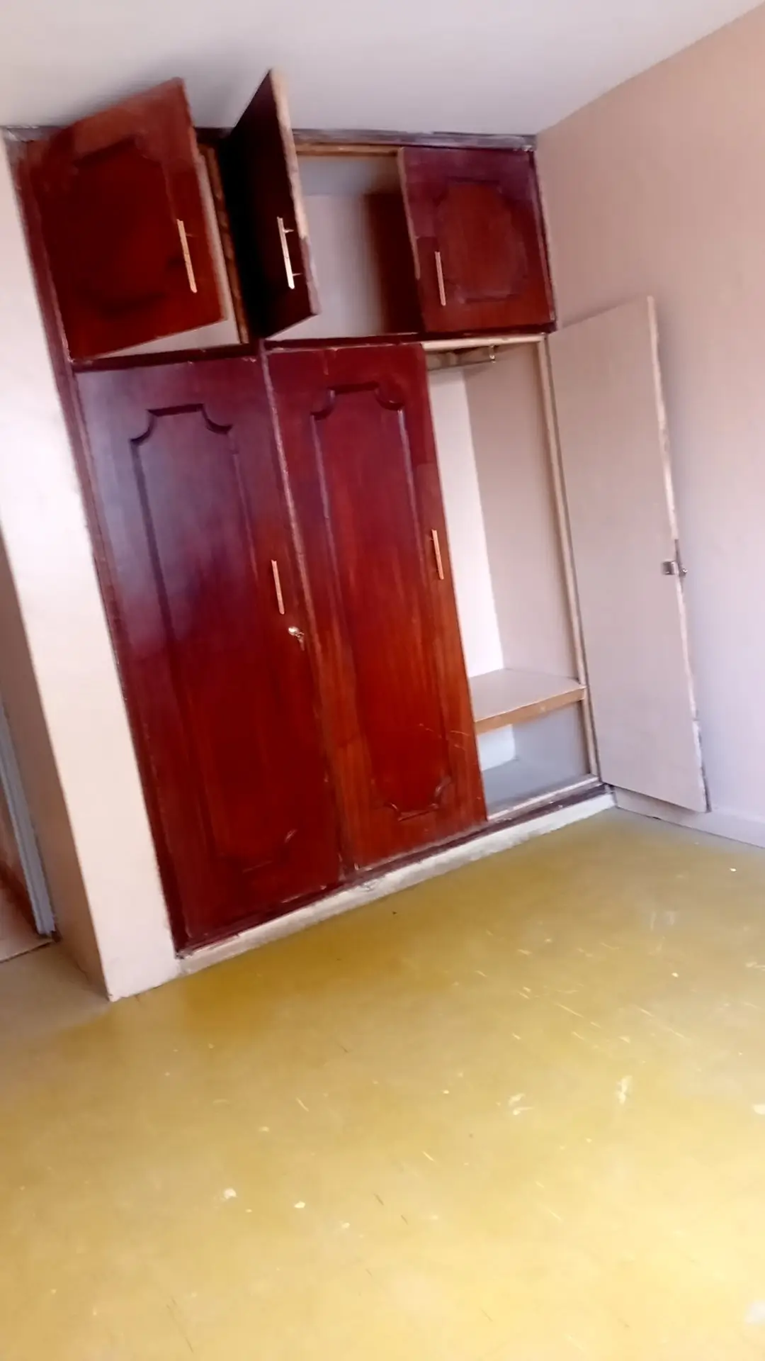 Empty bedroom with red built-in wardrobe and polished floor