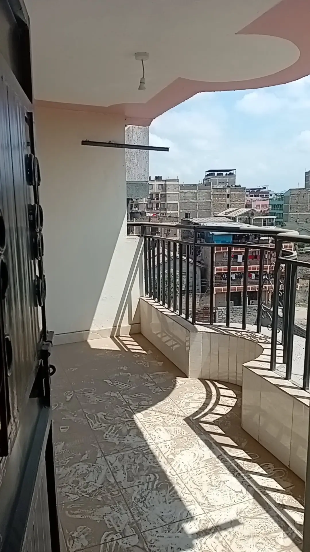 Spacious balcony with city skyline views and metal railings