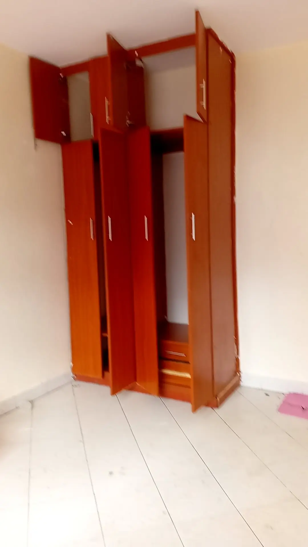 Red wooden wardrobe cabinet in empty bedroom space