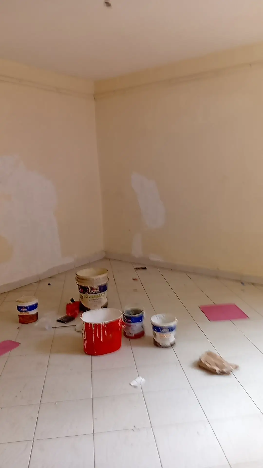 Empty bedroom under renovation with paint cans and supplies