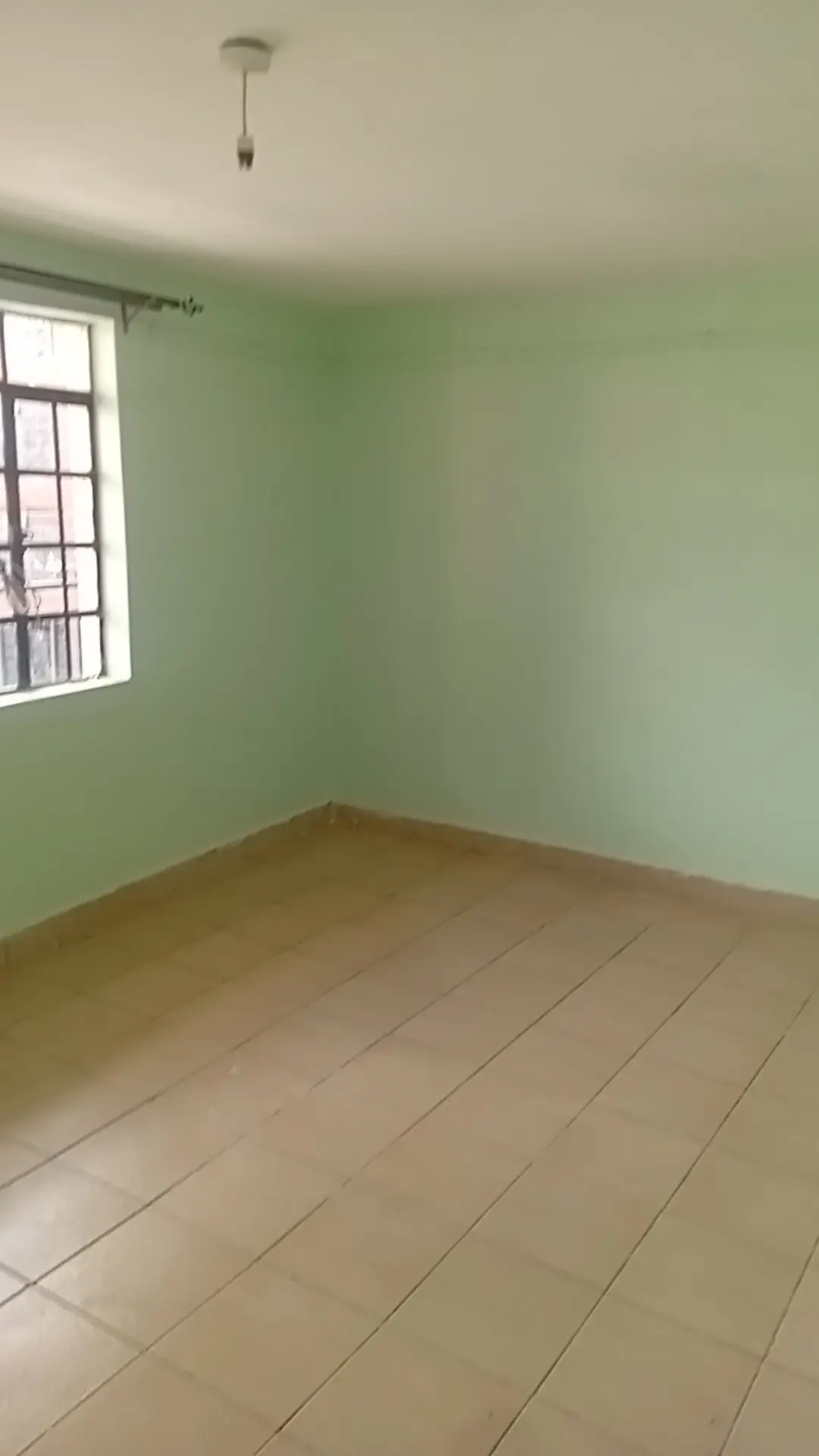 Empty room with green walls and tiled floor