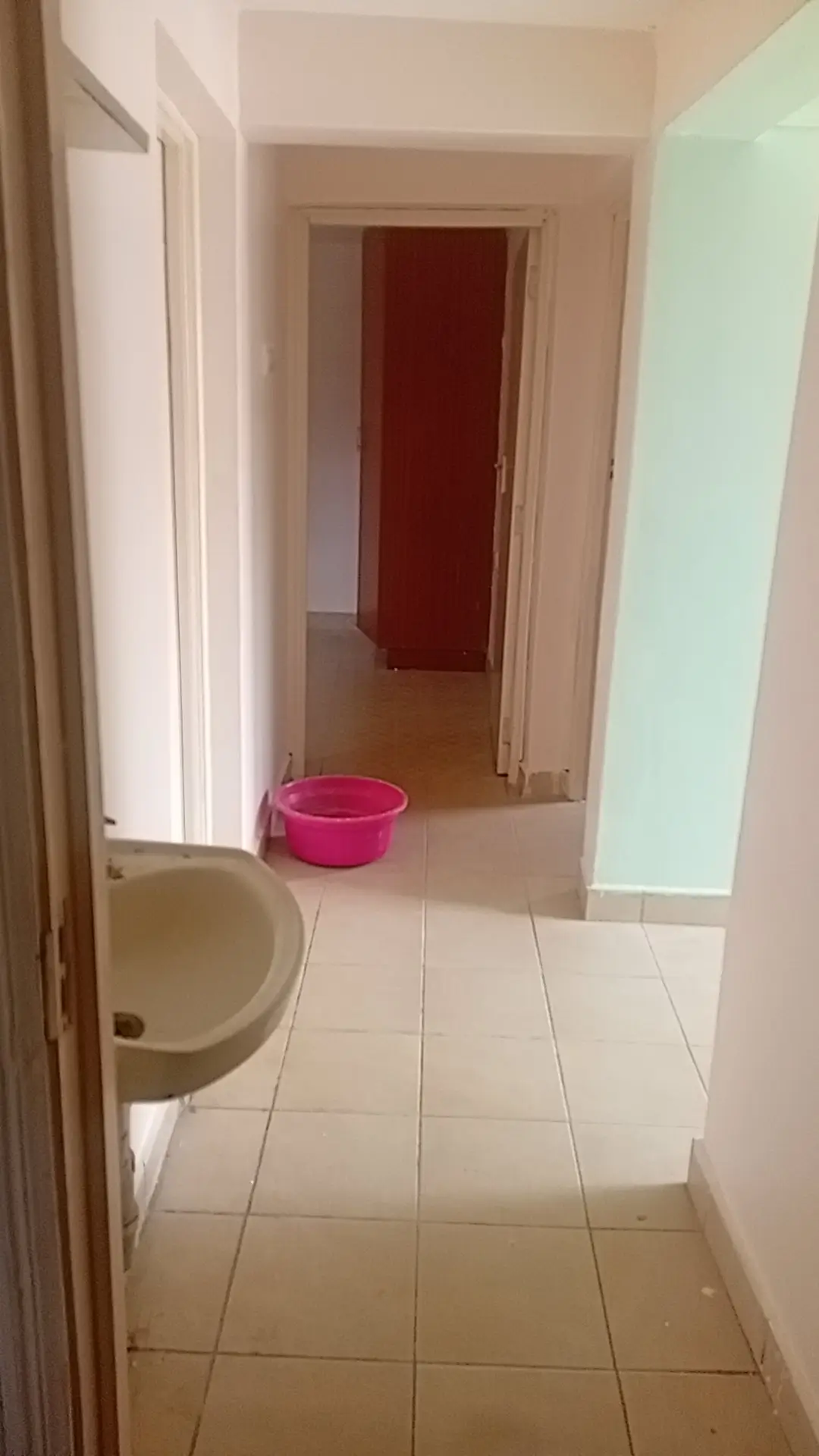 Bathroom with toilet visible, corridor perspective beyond