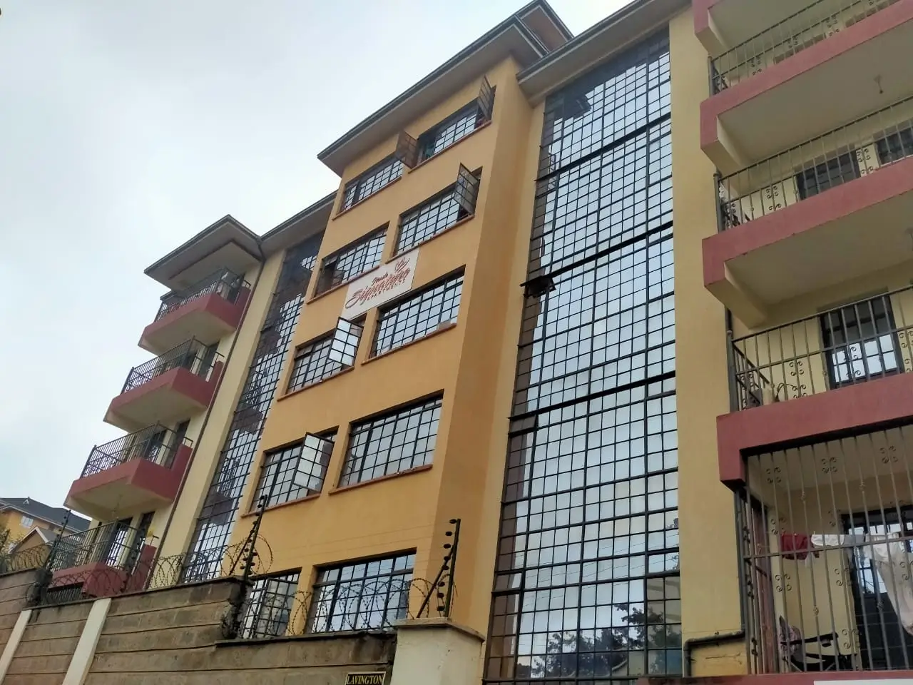 Multi-story residential building facade with yellow and red trim